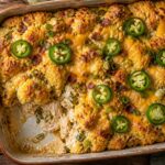 Jalapeno popper cornbread chicken casserole served on a plate, showing golden cornbread topping with melted cheese and creamy chicken filling.