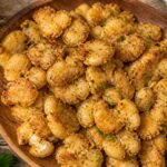 Golden crispy air fryer ranch smashed white beans piled on a wooden board, perfectly browned and seasoned.