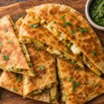 Crispy air fryer samosa quesadillas cut into wedges, served on a plate with mint and tamarind chutney.