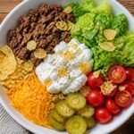 Cottage Cheese Cheeseburger Crunch Bowl with ground beef, lettuce, tomatoes, pickles, and chips