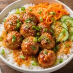 Swicy apricot chicken meatball bowls with rice, carrots, cucumber, and green onions, drizzled with sauce