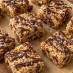 Brown butter tahini rice krispie date bars cut into squares on a parchment-lined pan