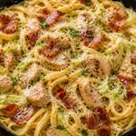 A skillet of creamy cabbage carbonara chicken pasta with bacon and Parmesan, garnished with parsley