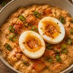 Savory oatmeal bowl with kimchi and jammy eggs, garnished with green onions and sesame seeds