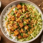 Air fryer crispy tofu cabbage satay bowls with peanut sauce, rice, and garnishes on a wooden table