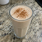 A homemade high-protein shake in a glass on a kitchen counter.