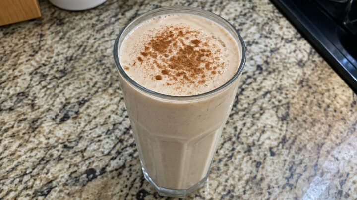 A homemade high-protein shake in a glass on a kitchen counter.