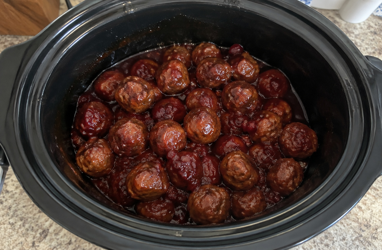 Glazed cranberry meatballs inside a slow cooker.